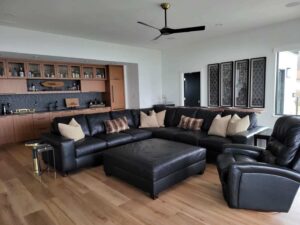 portfolio image of living room with large black couch and bar