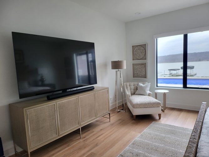 portfolio image of bedroom with large tv and view of pool